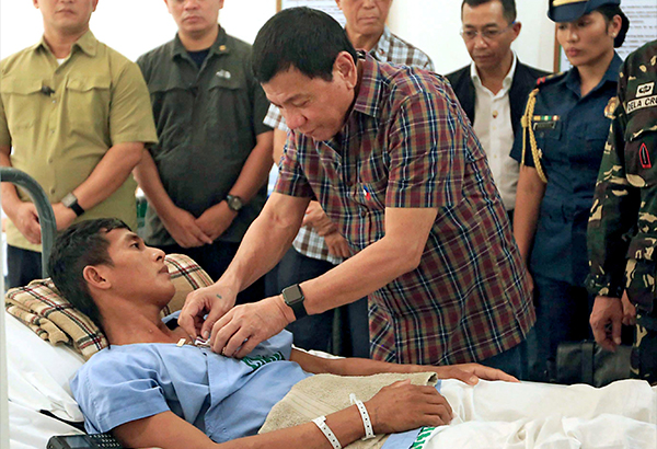 Photo taken on Wednesday shows President Duterte pinning a medal on a ...