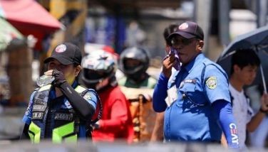 Members of the Metropolitan Manila Development Authority (MMDA) and Traffic and Parking Management Office (TPMO) carry bottled water while on duty in Alabang-Zapote Road on April 3, 2024