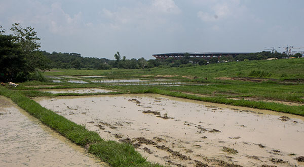 The New Clark City Sports Complex is seen in the distance from a small family farm in Aranguren.