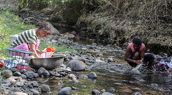Residents wash their laundry in a nearby creek. This creek also serves as one of their main sources of water aside from hand pumps.