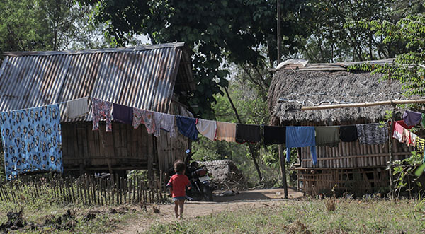 A child walks towards houses of the Aeta community at Sitio Bagingan in Capas, Tarlac.