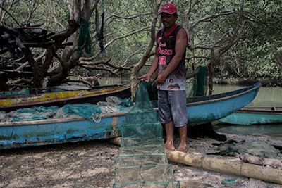 Rodel Alvarez, paddles a small boat across the narrow part of the Manila bay, where there used to be fishponds.