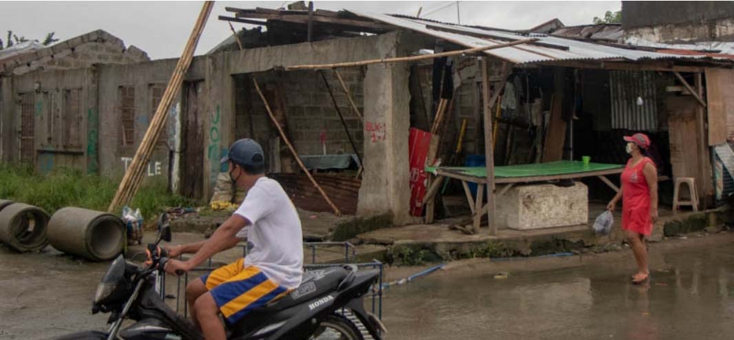 Residents pass by destroyed housing units in Kasiglahan Village in Rodriguez, Rizal on September 11, 2021
