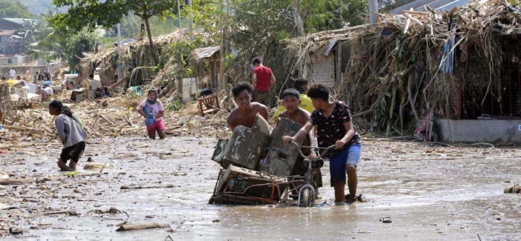 Residents walked through mud in November 2020 following the onslaught of Typhoon Ulysses (Vamco) which triggered massive flooding