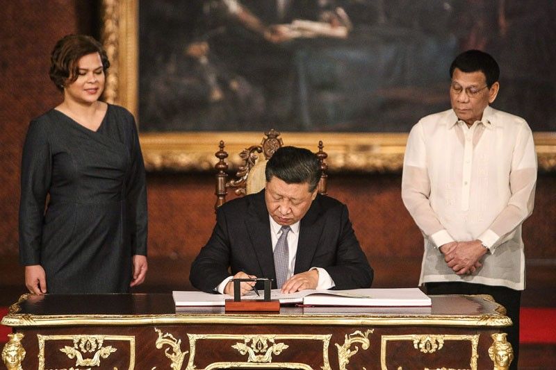 President Duterte and daughter Sara Duterte-Carpio looking on as Xi signs the Malacañang guest book. Image: Philstar Global
