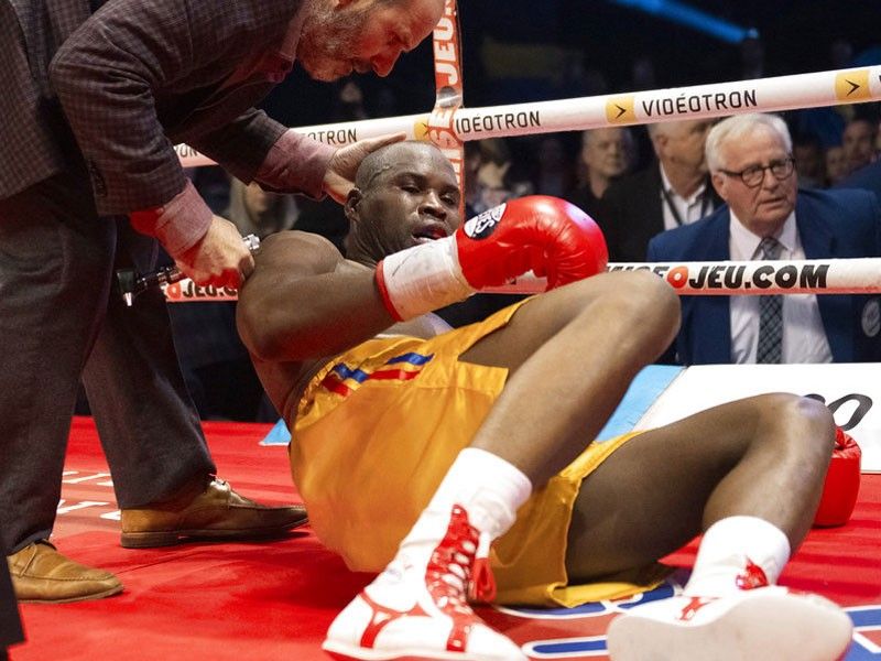 Ring doctor Marc Gagne, left, checks on Adonis Stevenson, of Canada, after he was knocked out by Oleksandr Gvozdyk, of Ukraine, in their light heavyweight WBC championship boxing fight, Saturday, Dec. 1, 2018, in Quebec City.