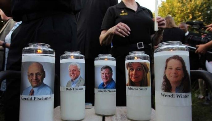 Small capital city draped in grief by newspaper shooting