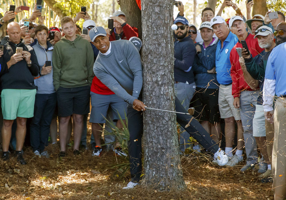 Woods shoots 70 thanks to par-saving shot from trees