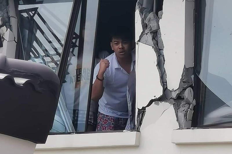 A resident calls for help inside their damaged condominium building after a 6.5-magnitude earthquake hit Davao City, on the southern island of Mindanao on October 31, 2019. 