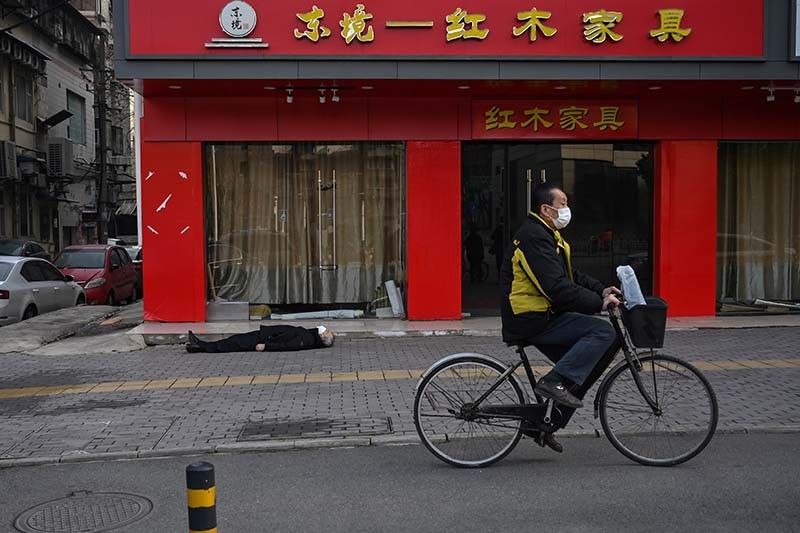 Dead man lies on an empty street at China's virus ground zero