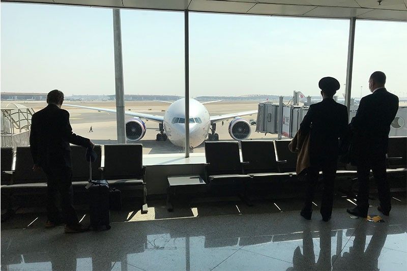 China cuts international flights, bars foreign residents