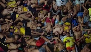 In this photo taken on March 27, 2020, prison inmates lie to sleep at the crowded courtyard of the Quezon City jail in Manila