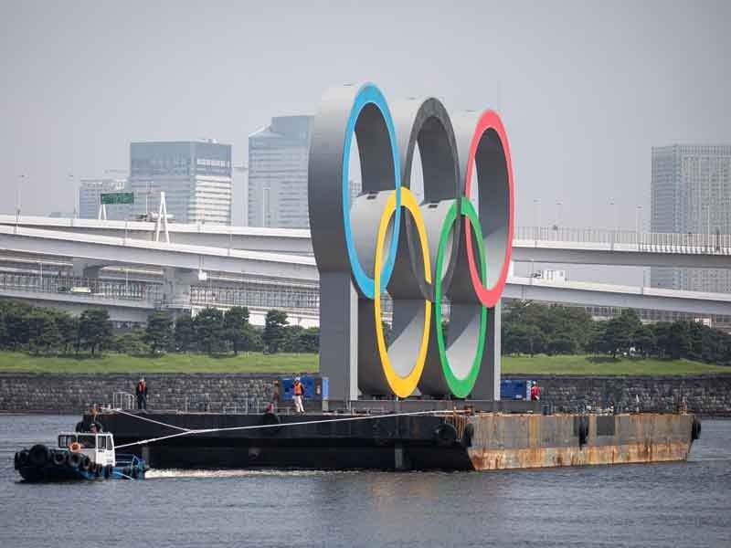 Giant Olympic rings in Tokyo towed away for maintenance
