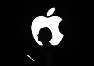 In this file photo a reporter walks by an Apple logo during a media event in San Francisco, California on September 9, 2015.
