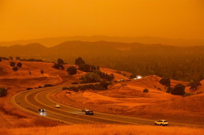 US homes destroyed as firefighters battle wildfires under orange skies