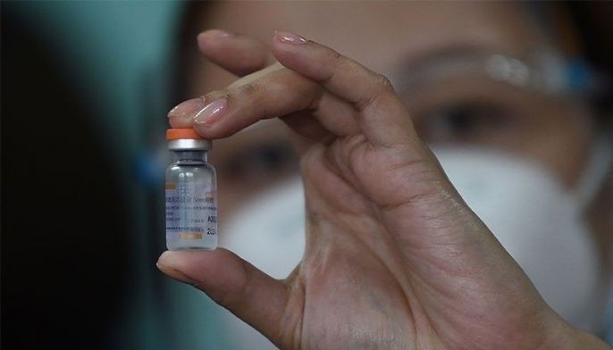 A health worker holds up a vial of China's Sinovac COVID-19 vaccine during the first phase of vaccinations for health workers at a hospital in Manila on March 1, 2021.
