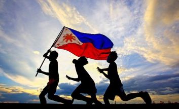 Children from Baseco compound in Manila run with a Philippine flag, representing proud independence and self-determination for the country. Philippines is celebrating the 123rd Independence Day on June 12, 2021.