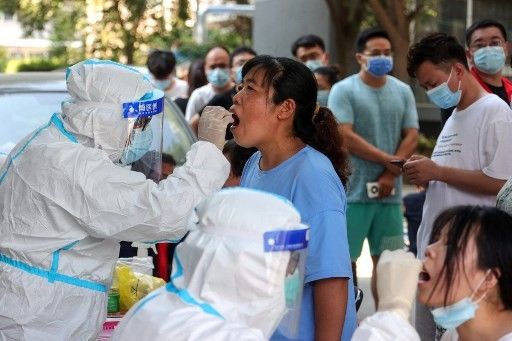 Chinese cities test millions as virus cases surge