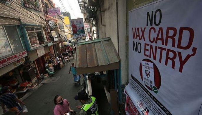 Authorities ask for vaccination cards from individuals and motorists entering Taguig City during their vaccination checkpoint operation held at Brgy. North Daang Hari on Jan. 21, 2022.