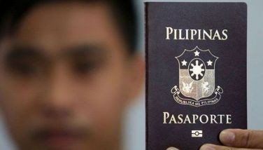 File photo shows a man holding a Philippine passport.