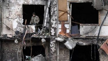 A Ukrainian serviceman is seen in the window of a damaged residential building at Koshytsa Street, a suburb of the Ukrainian capital Kyiv, where a military shell allegedly hit, on February 25, 2022. Russian forces reached the outskirts of Kyiv on Friday as Ukrainian President Volodymyr Zelensky said the invading troops were targeting civilians and explosions could be heard in the besieged capital. Pre-dawn blasts in Kyiv set off a second day of violence after Russian President Vladimir Putin defied Western warnings to unleash a full-scale ground invasion and air assault on Thursday that quickly claimed dozens of lives and displaced at least 100,000 people.