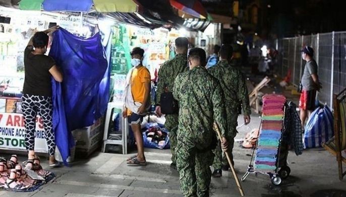Armed with yantoks, members of the Southern Police District roam around Barangay Baclaran in Para&Atilde;&plusmn;aque City on Monday night, March 15, 2021, to remind the public of the strict implementation of the unified curfew hours from 10 p.m. to 5 a.m. in an effort to curb the spread of COVID-19.