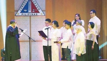 Quezon City Mayor Joy Belmonte is joined by her family as she takes her oath before Chief Justice Alexander Gesmundo during a swearing-in ceremony for city officials at the EVM Convention Center in Quezon City yesterday.