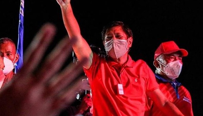 This photo taken on April 24, 2022 shows presidential candidate Ferdinand Marcos Jr (C) waving during a campaign rally in Taguig, suburban Manila ahead of the presidential election on May 9.
