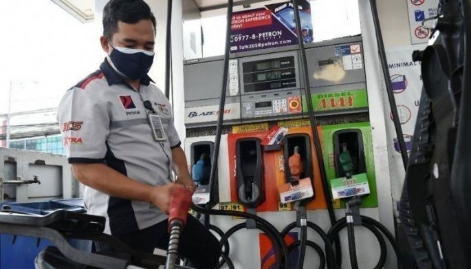 An attendant fills up a tricycle with gasoline at a petrol station in Manila on March 15, 2022.