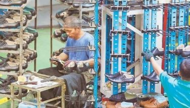 Shoemakers at a factory in Marikina City work on their day off yesterday to meet the high demand for school shoes ahead of the resumption of in-person classes on Aug. 22.