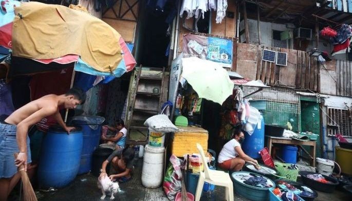 Families go about with their day as they extend their space in front of their shanties along a road in Delpan, Tondo, Manila on August 21, 2022.