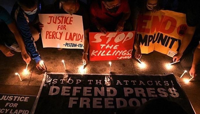 Demonstrators light candles at a rally calling for justice following the murder of a Philippine radio broadcaster, in Quezon City in suburban Manila on October 4, 2022. 