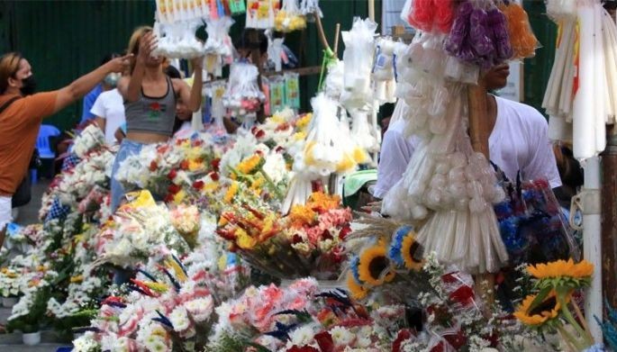 Flower vendors display their products for sale outside the Manila North Cemetery on October 16, 2022, hoping for a good income as cemeteries reopen for Undas week.