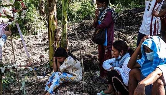 Relatives grieve at a mass burial site where the Sapi family buried seven of their members, victims of the landslide in the nearby village at the height of Typhoon Nalgae, in Datu Odin Sinsuat, Maguindanao, southern Philippines on October 31, 2022.