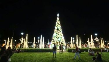 Visitors enjoy taking pictures with the colorful dancing fountain and glistening Christmas decorations around Rizal Park in Manila on November 28, 2022.