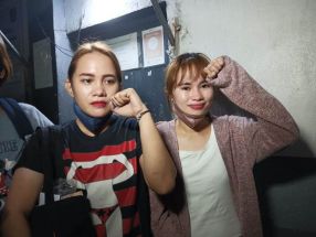 Activists Alma Moran and Reina Mae Nasino raise clenched fists on Dec. 22, 2022 following their release on bail.