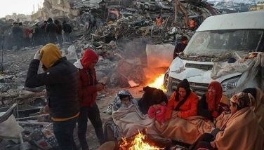 Survivors gather next to a bonfire outside collapsed buildings in Kahramanmaras on February 8, 2023, after their homes were destroyed in a 7.8 magnitude earthquake which struck the border region of Turkey and Syria on February 6. Turkish President Recep Tayyip Erdogan has conceded &quot;shortcomings&quot; after criticism of his government's response to the massive earthquake that killed over 11,700 people in Turkey and Syria. The sprawling scale of the disaster that flattened thousands of buildings, trapping an unknown number of people, has swamped relief operations already hampered by freezing weather.  