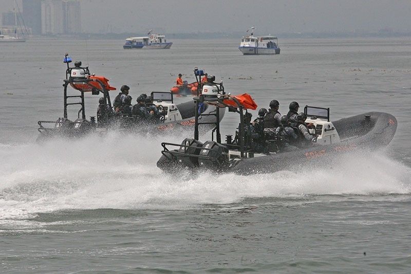 In this July 2019 file photo, Philippine Coast Guard personnel conduct drills on rigid hull inflatable boats.