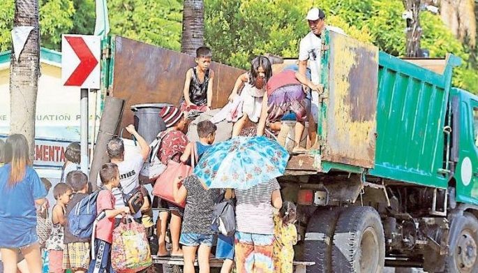 Residents board a truck as they evacuate their village due to an eruption threat from nearby Mayon Volcano in Daraga, Albay yesterday. Phivolcs scientists said a &acirc;��hazardous eruption&acirc;�� of the volcano could be days or weeks away, and urged the evacuation of nearby residents from their homes.