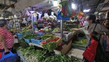 Vendors attend to their customers as they sell vegetables at Paco Public Market in Manila.