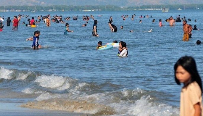 Local tourists and residents enjoy the beach in Binmaley, Pangasinan on Black Saturday, ahead of the Easter Sunday celebration.