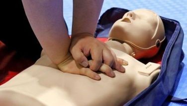 A person doing cardiopulmonary resuscitation on a mannequin.