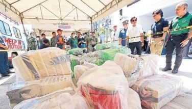 In what was seen as a subtle dig at his predecessor&acirc;��s bloody war on drugs, President Marcos inspects P13.3 billion worth of shabu, which he said was the largest drug haul in years that was conducted without anybody being killed, in Alitagtag, Batangas yesterday. Looking on is Interior and Local Government Secretary Benhur Abalos.