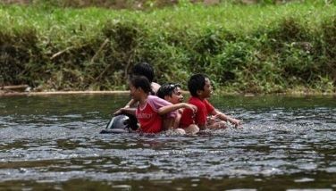Children ride on a swimming floatie along Norzagaray River in Bulacan on April 6, 2024. The months of March, April and May are typically the hottest and driest in the archipelago nation, but conditions this year have been exacerbated by the El Nino weather phenomenon.