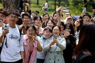 Chinese students wait for the arrival of French President Emmanuel Macron at Sun Yat-sen University in Guangzhou on April 7, 2023.
