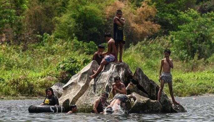 People take a dip along Norzagaray River in Bulacan on April 6, 2024. The months of March, April and May are typically the hottest and driest in the archipelago nation, but conditions this year have been exacerbated by the El Nino weather phenomenon. 