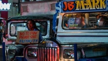 A man holds a placard as he joins a protest caravan to oppose the government&acirc;��s jeepney modernisation plan, in Manila on April 15, 2024.