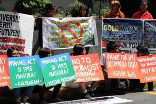 Members of a student environmental group and residents picket in front of the office of Australia-based mining company OceanaGold in the financial district of Manila on March 4, 2015.