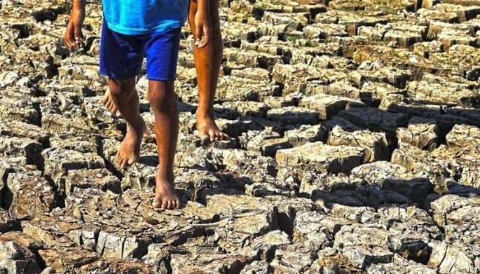 Locals walk over the dry part of Intang Lake in Pantabangan, Nueva Ecija on April 22, 2024.