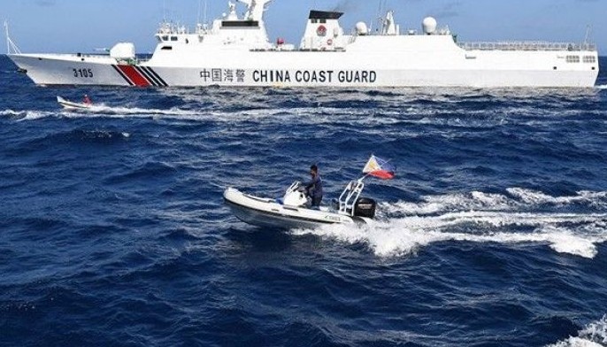 This photo taken on February 16, 2024 shows Filipino fishermen aboard their wooden boats (middle L and 2nd L) and Philippine Fisheries and Aquatic Resources personnel aboard their rigid hull inflatable boat (foreground C) sailing past a Chinese coast guard ship (top) near the China-controlled Scarborough Shoal, in disputed waters of the South China Sea. The Philippines on February 17 accused Chinese coast guard vessels of &quot;dangerous&quot; manoeuvres for attempting to block a Filipino vessel dropping supplies to fishermen at a reef off the Southeast Asian nation's coast.